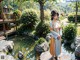 A woman in a kimono standing in front of a pond.