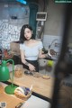 A woman standing in a kitchen preparing food.