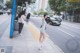 A woman in a white dress is walking down the street.