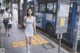 A woman in a white dress is walking down the street.