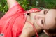 A woman in a red dress laying on the ground.