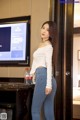 A woman standing in front of a television in a hotel room.