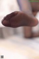 A close up of a person's foot in black stockings.