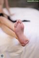 A woman laying on top of a bed with her bare feet.