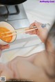 A naked woman holding chopsticks over a bowl of soup.