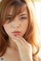 A woman with long brown hair is posing for a picture.