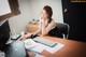 A woman sitting at a desk using a computer.