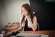 A woman sitting at a desk with a keyboard and mouse.