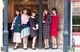 A group of women standing next to each other in front of a building.