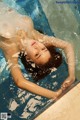 A woman in a white dress is floating in a pool.