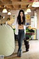 A woman standing next to a pool table holding a can of beer.