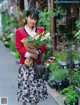 A woman walking down a street holding a bunch of flowers.