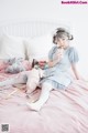 A woman sitting on a bed holding a glass of milk.